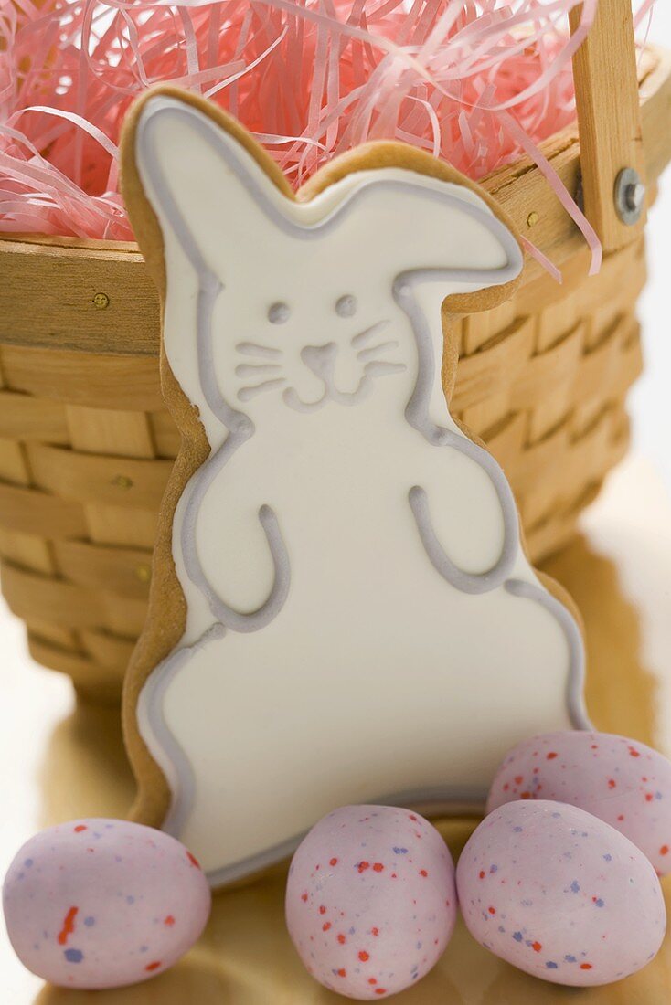 Easter biscuit (Easter Bunny) & sugar eggs in front of basket