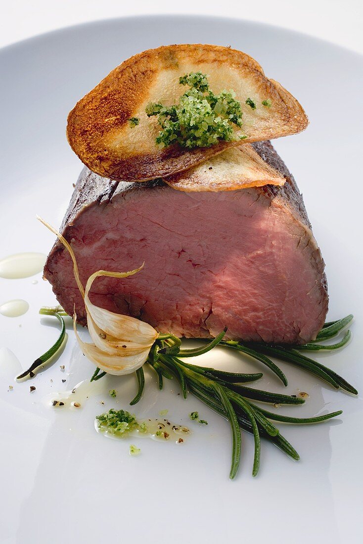 Roast fillet of beef with vegetable crisps, rosemary, garlic