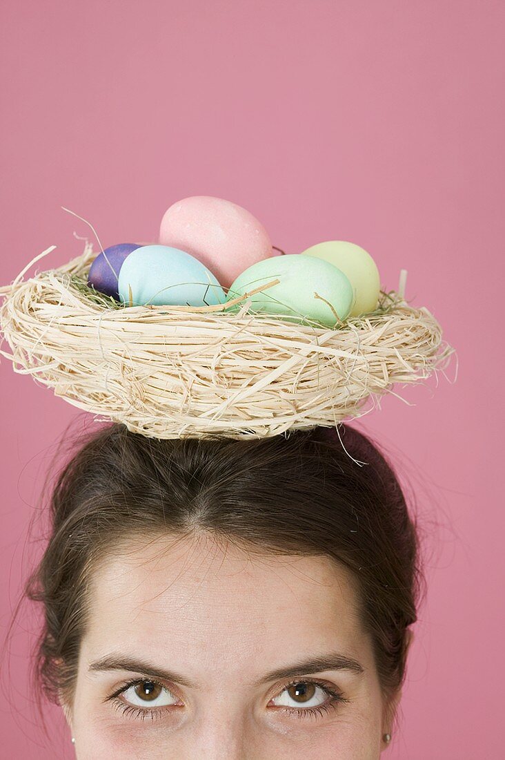 Woman carrying basket of coloured eggs on her head