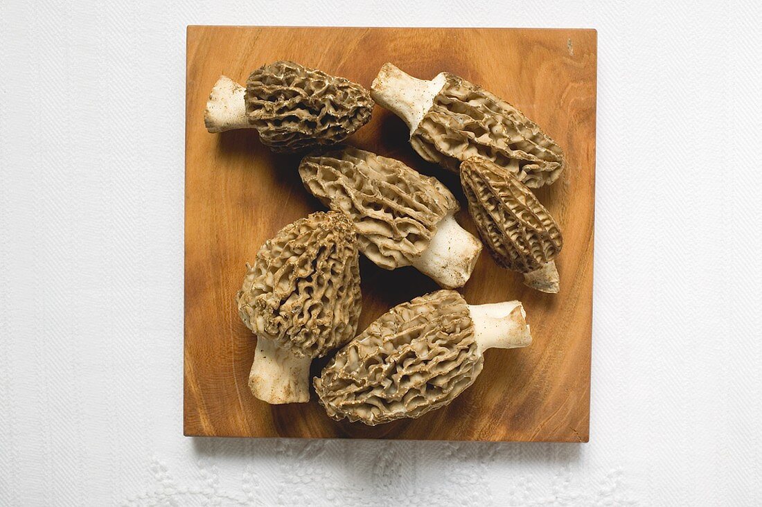 Several morels on wooden board