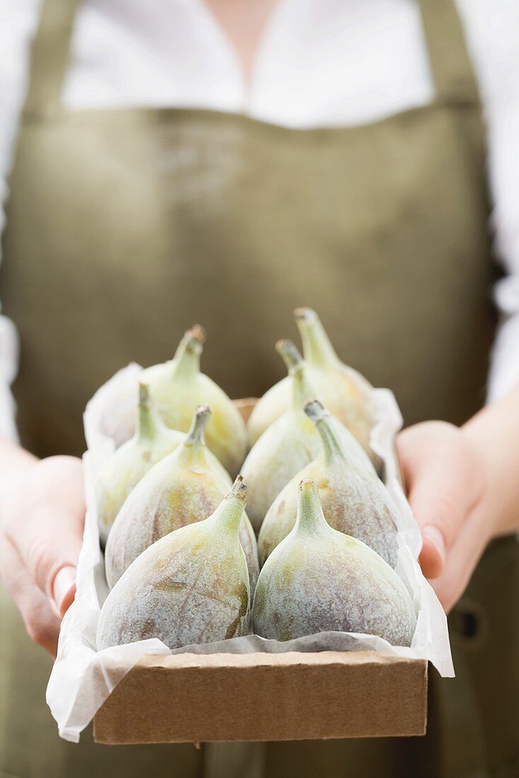 Woman holding box of fresh figs