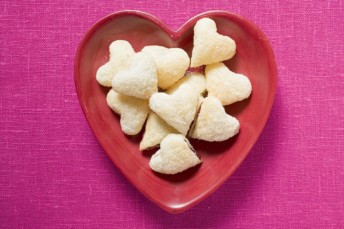Heart-shaped jam-filled biscuits in red dish