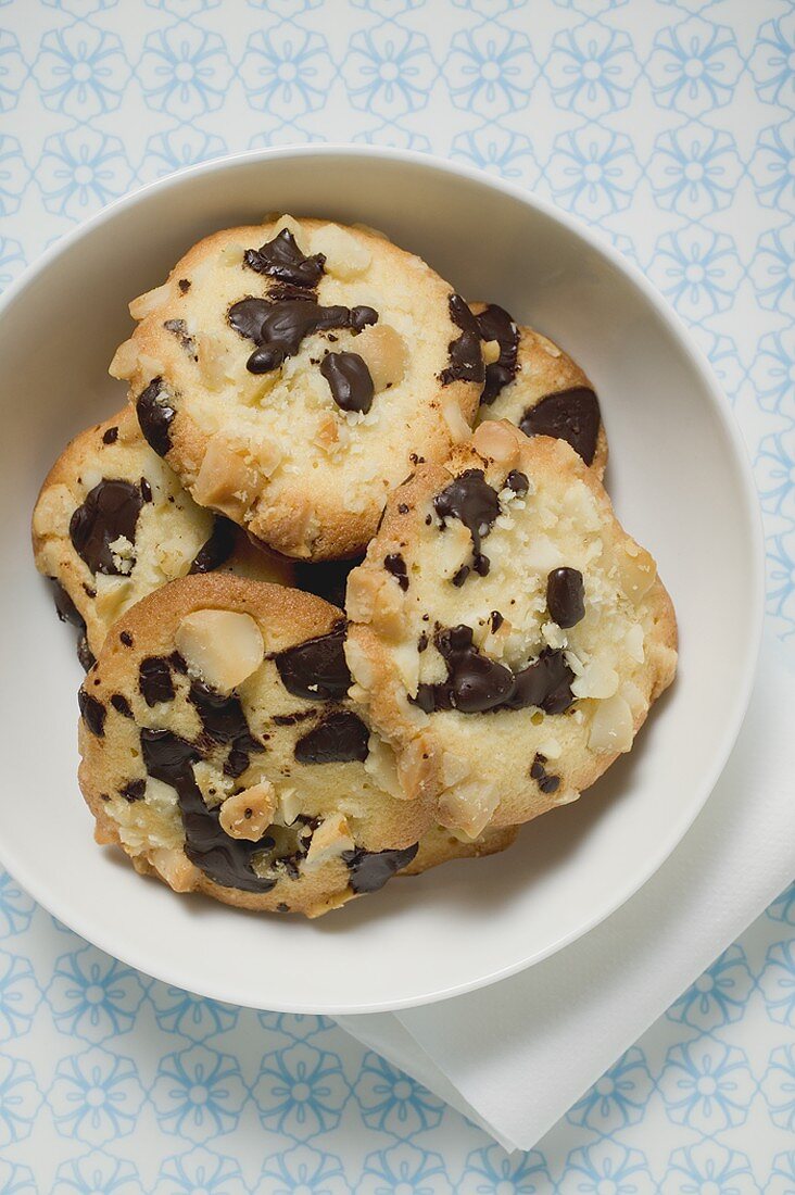 Chocolate chip peanut cookies in white bowl