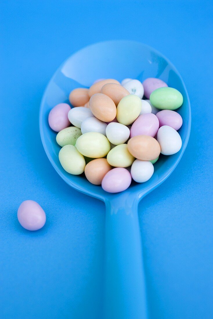 Sugar eggs on blue spoon (overhead view)