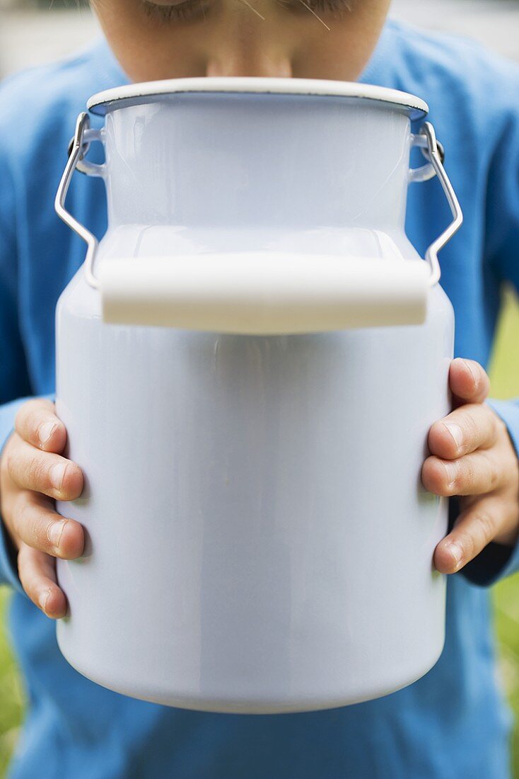 Child drinking milk out of milk can