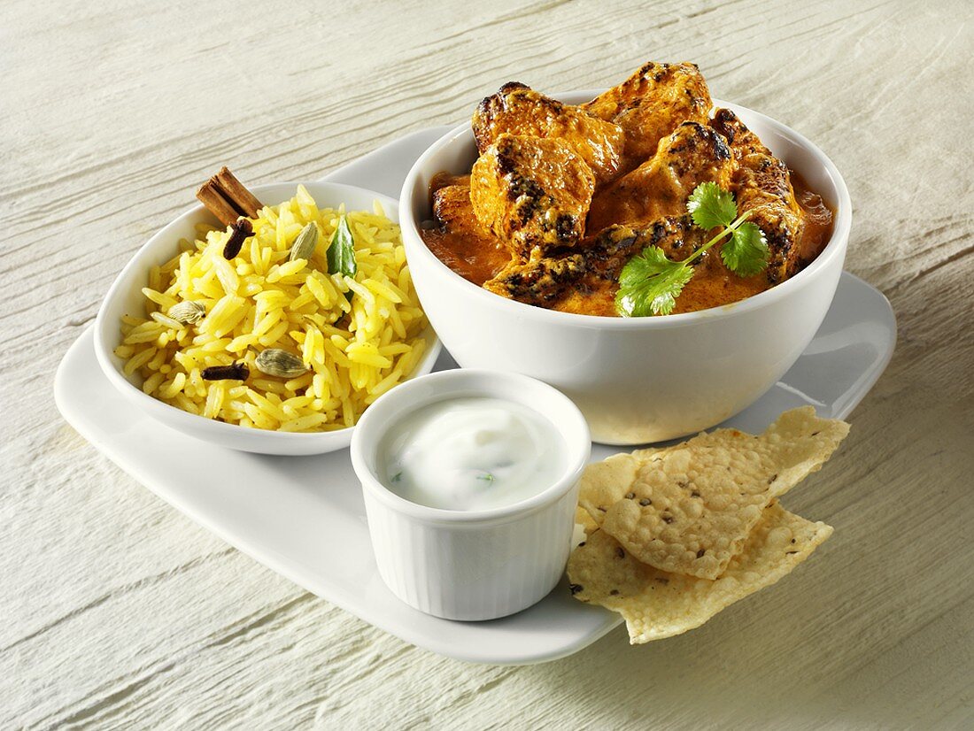 Curry mit Reis, Joghurtsauce und Fladenbrot (Indien)