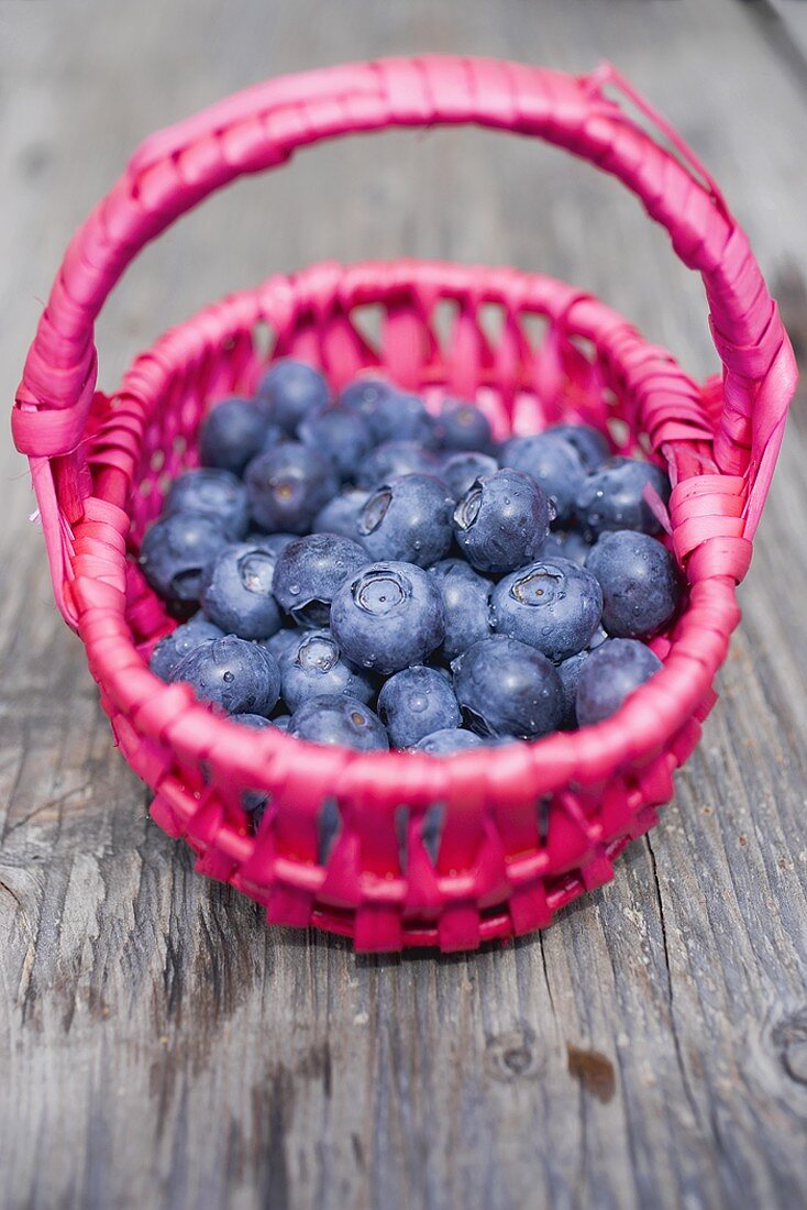 Heidelbeeren im Korb auf Holztisch