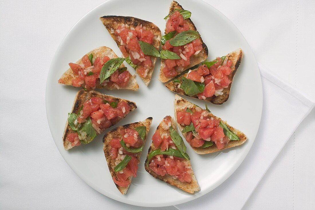 Bruschetta mit Tomatensalsa und Basilikum auf Teller