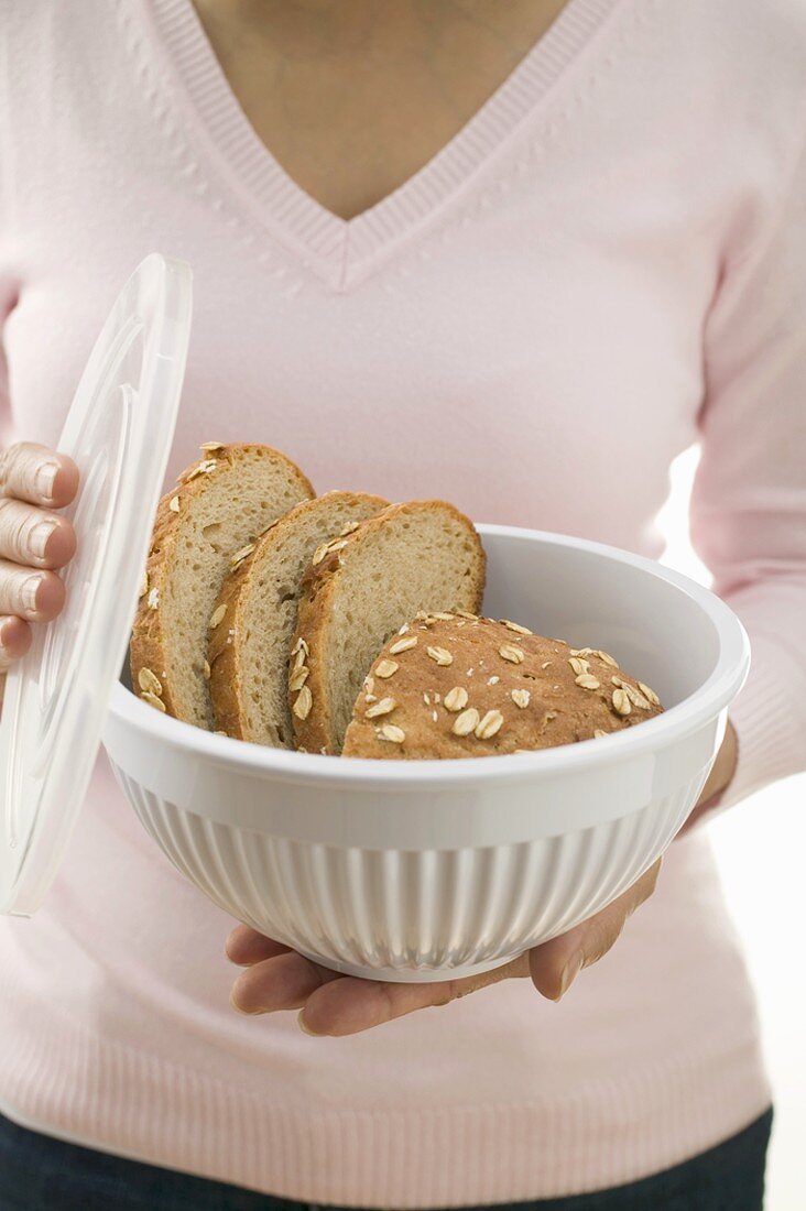 Woman holding oat bread in food storage container