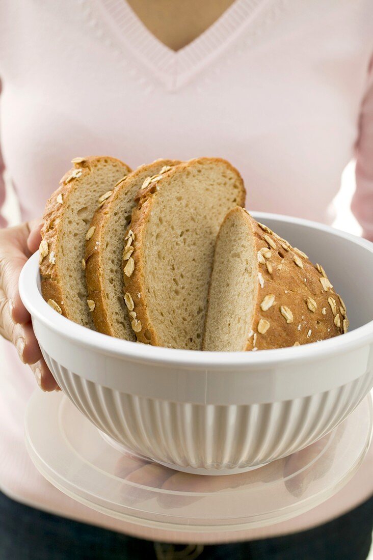 Woman holding oat bread in a food storage container