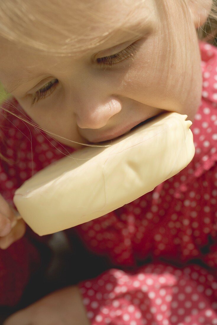 Small girl eating an ice cream on a stick