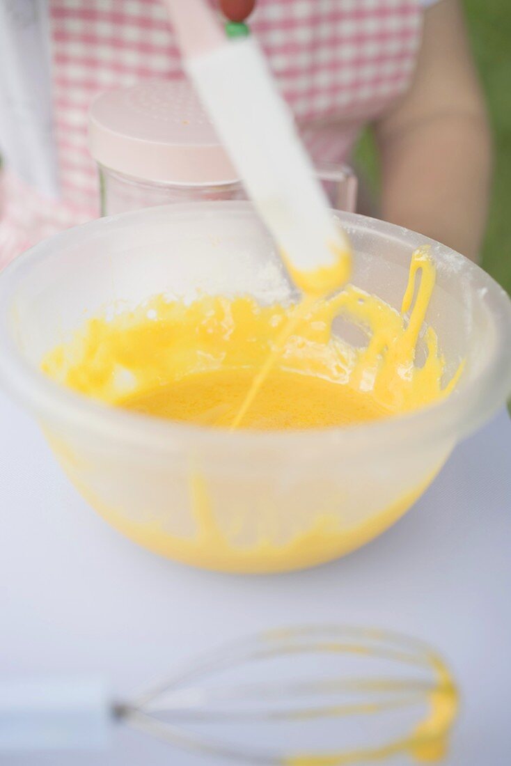 Child stirring egg mixture with spatula