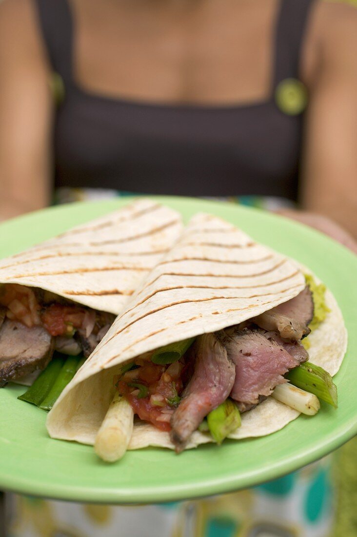 Woman serving meat and vegetable wraps
