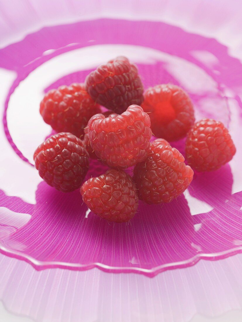 Frische Himbeeren auf pinkfarbenem Teller