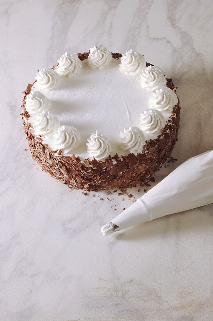 Buttercream cake with grated chocolate, piping bag beside it