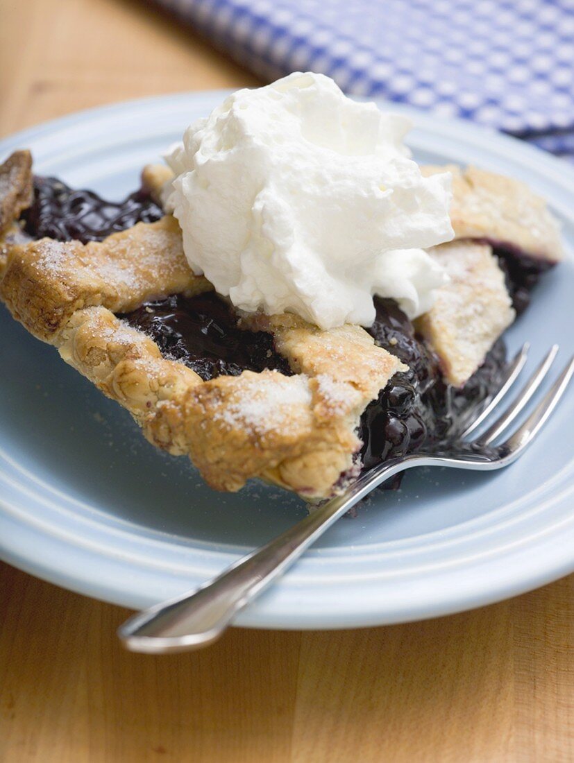 Piece of blueberry pie with cream