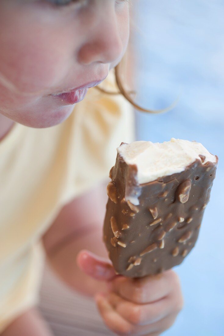 Kleines Mädchen isst Eis am Stiel