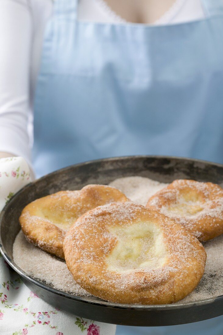 Woman holding Auszogene (Bavarian doughnuts)