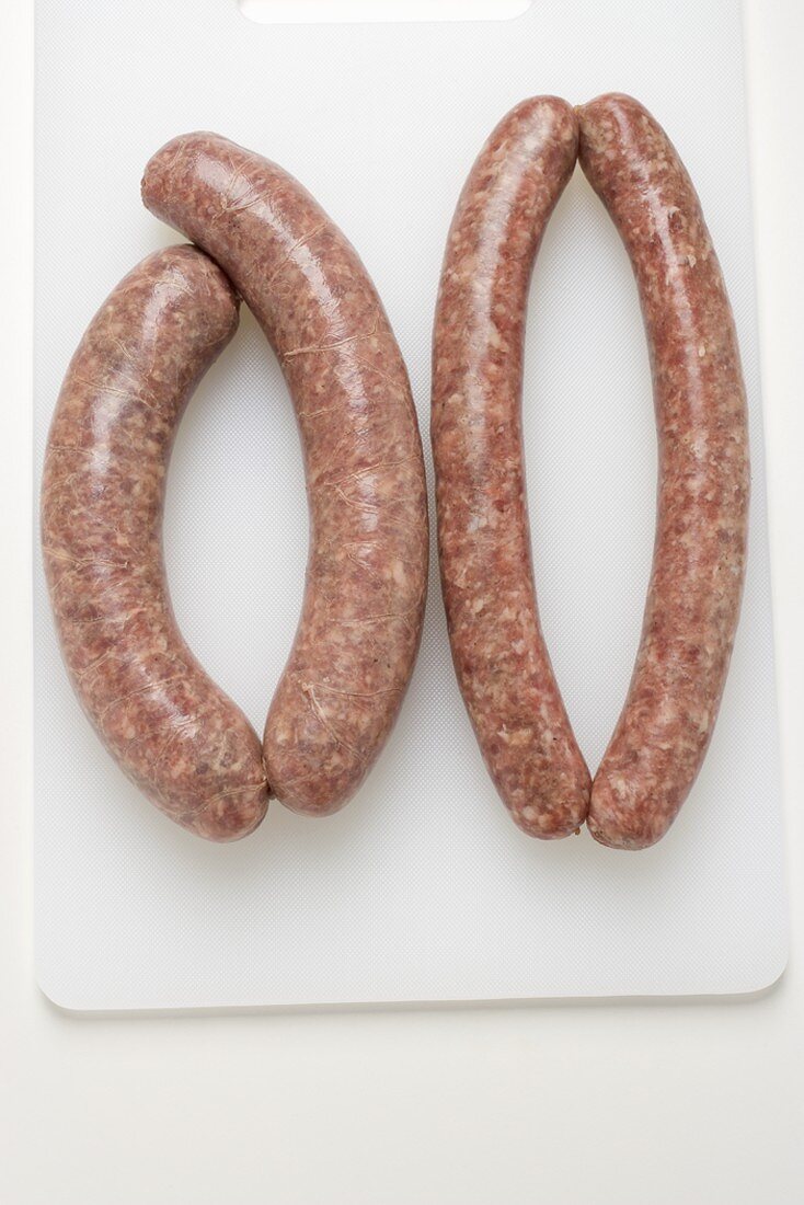 Two types of sausages on chopping board