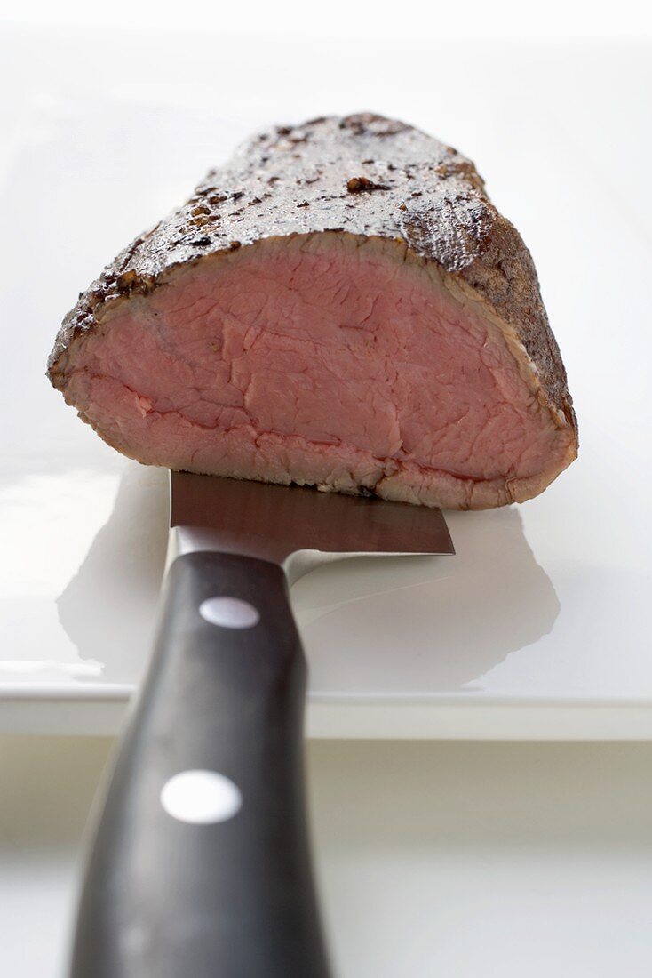 Roast beef fillet on knife