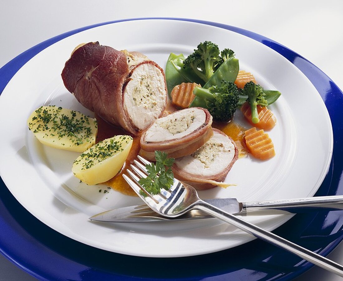 Stuffed ham-wrapped chicken breast with vegetables