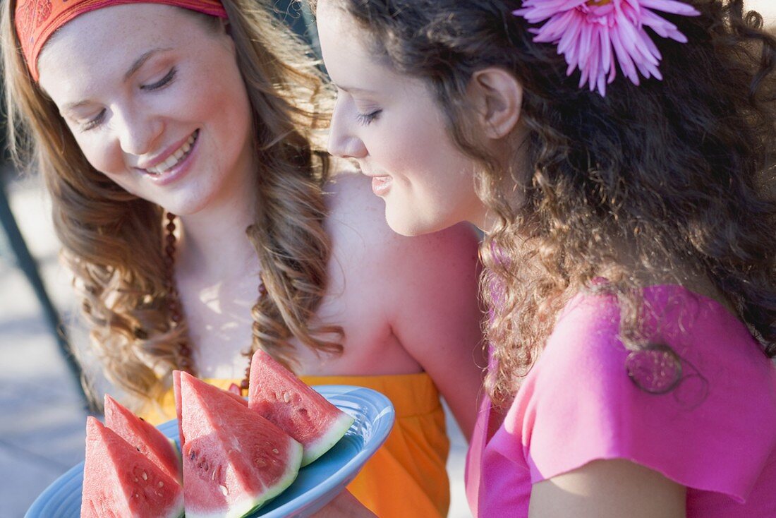 Zwei junge Frauen mit Wassermelonenschnitzen