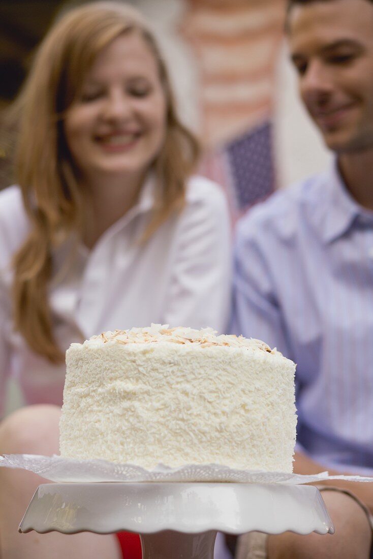 Coconut cake for the 4th of July, couple in background (USA)