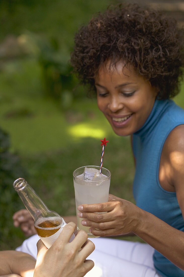 Frau mit Glas Limonade beim Gartenfest
