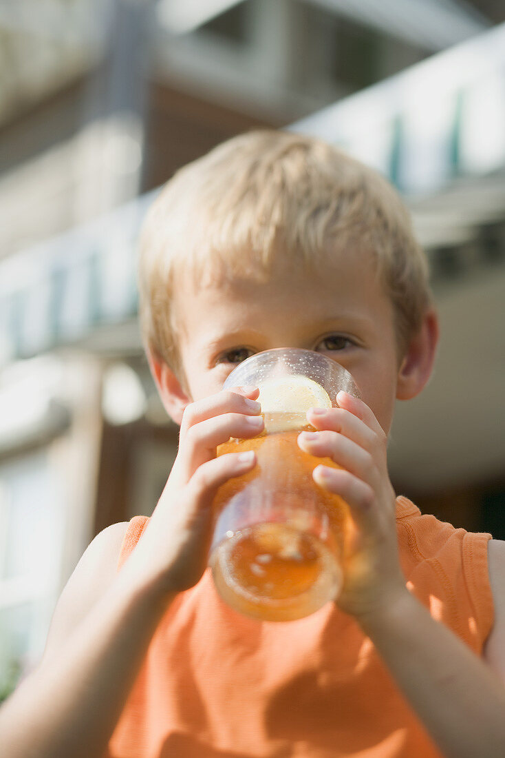 Kleiner Junge trinkt Glas Eistee