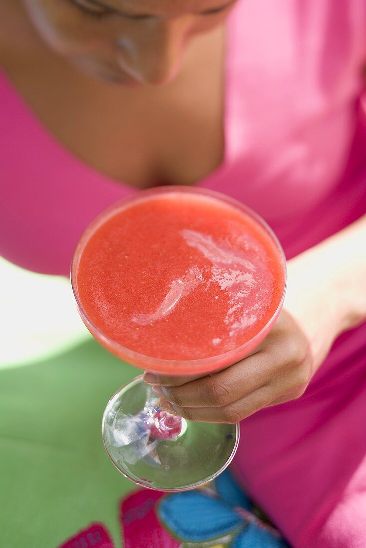 Frau hält fruchtigen Erdbeerdrink