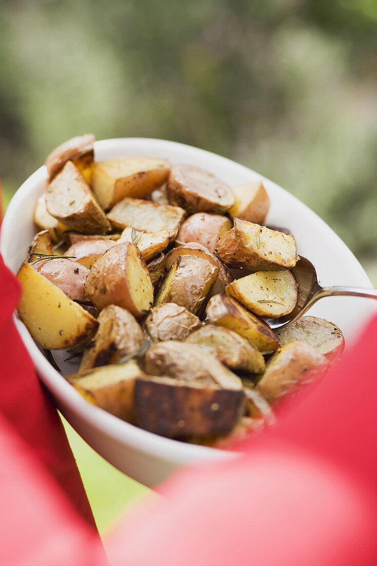 Rosemary potatoes in a dish with spoon