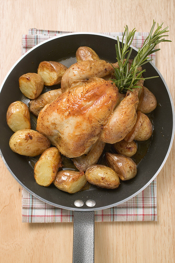 Chicken with roast potatoes in a frying pan