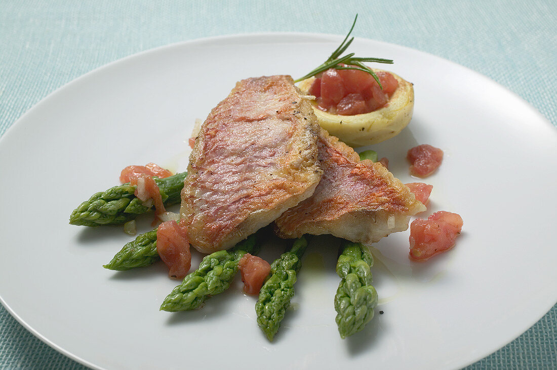 Fried red mullet fillets with asparagus and tomatoes