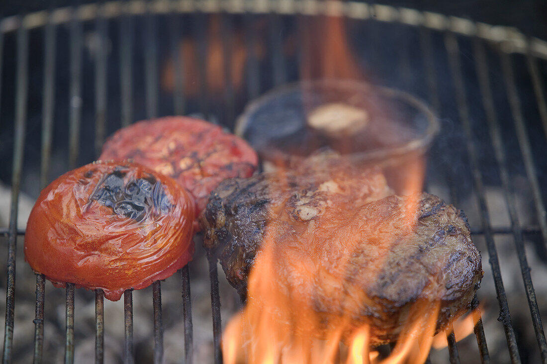 Beef steak and tomatoes on a barbecue