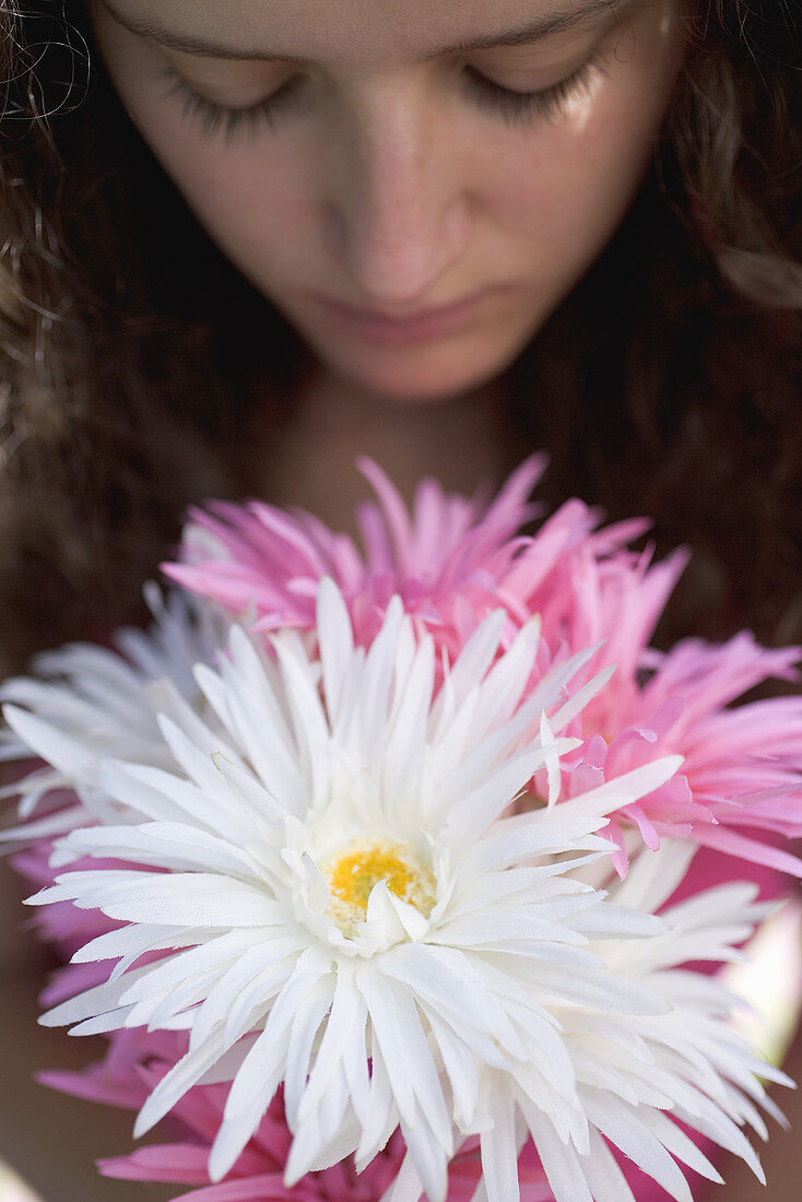 Young woman with bunch of summer flowers