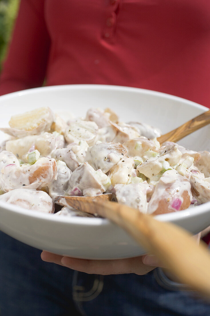 Person hält Schüssel mit Kartoffelsalat