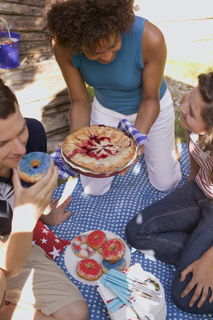 Young people with blueberry pie & doughnuts on the 4th of July