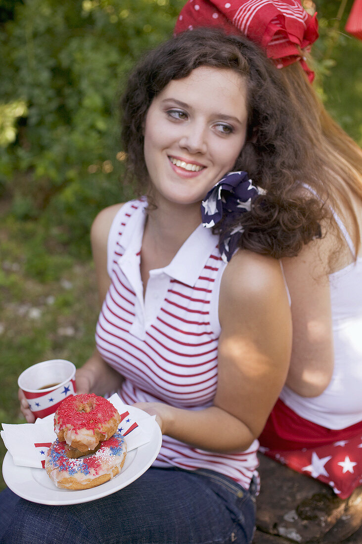 Young woman with doughnuts at a 4th of July picnic (USA)
