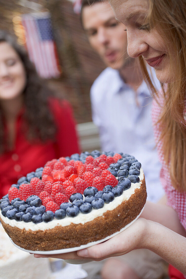 Woman holding a berry cake (4th of July, USA)
