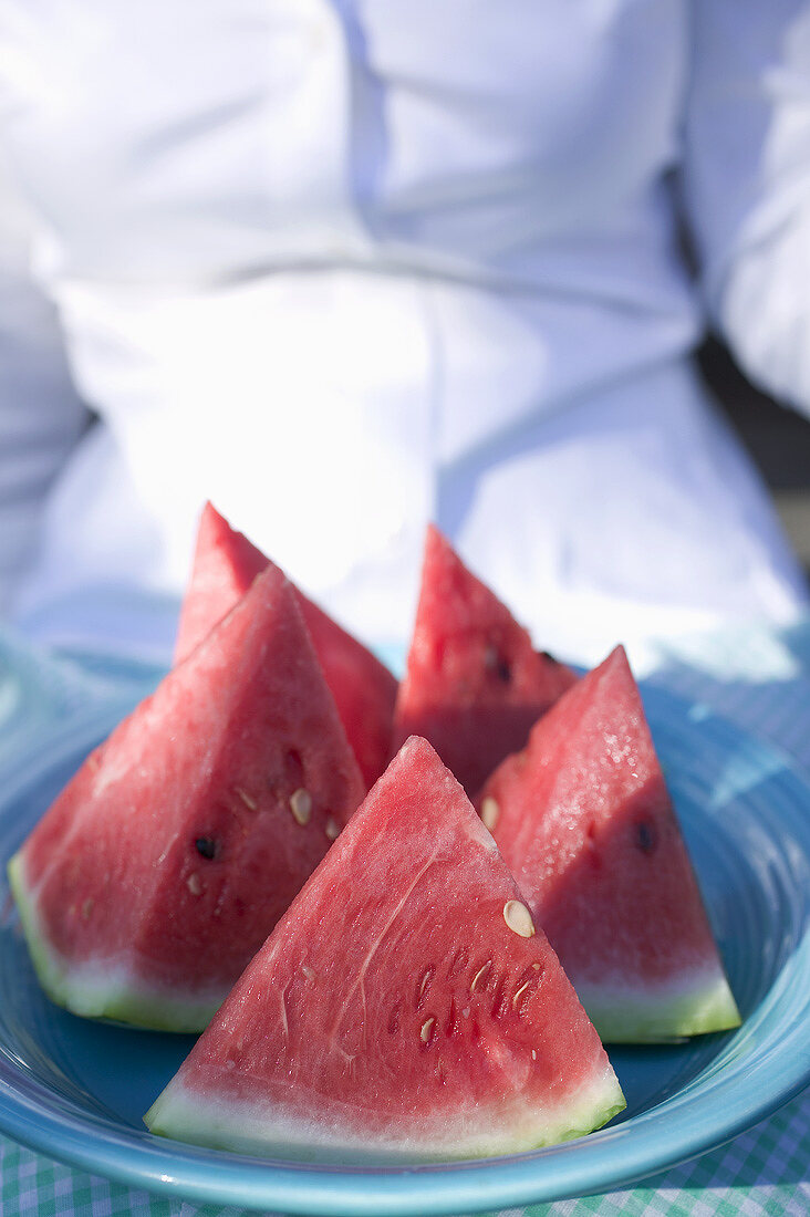 Woman holding a plate of watermelon wedges