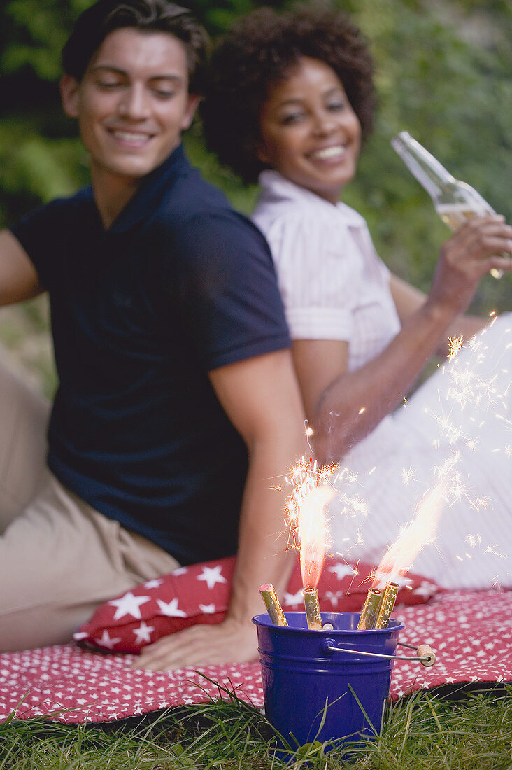 Paar mit Wunderkerzen beim Picknick am 4th of July (USA)