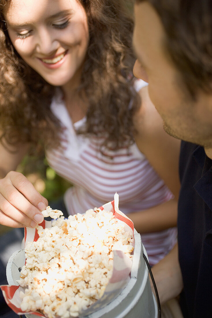 Paar isst Popcorn beim Picknick