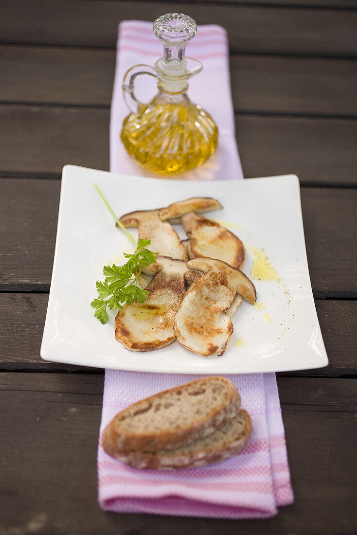 Gebratene Steinpilzscheiben mit Petersilie, Olivenöl und Brot