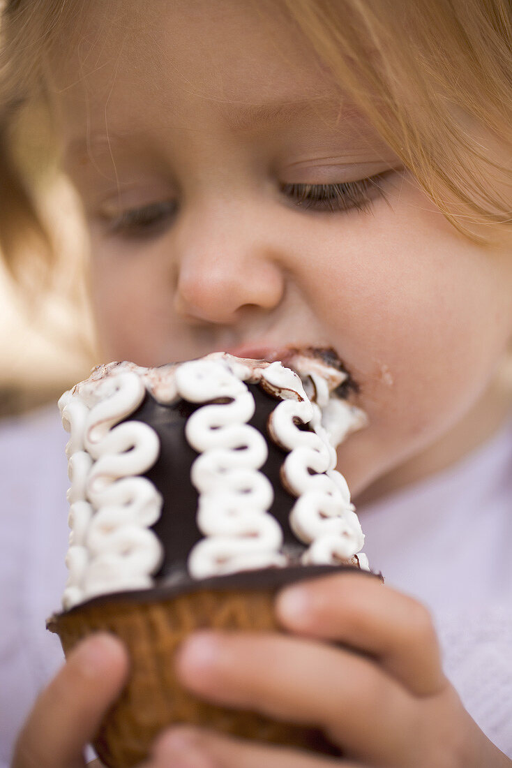 Kleines Mädchen isst Schokoladeneistüte