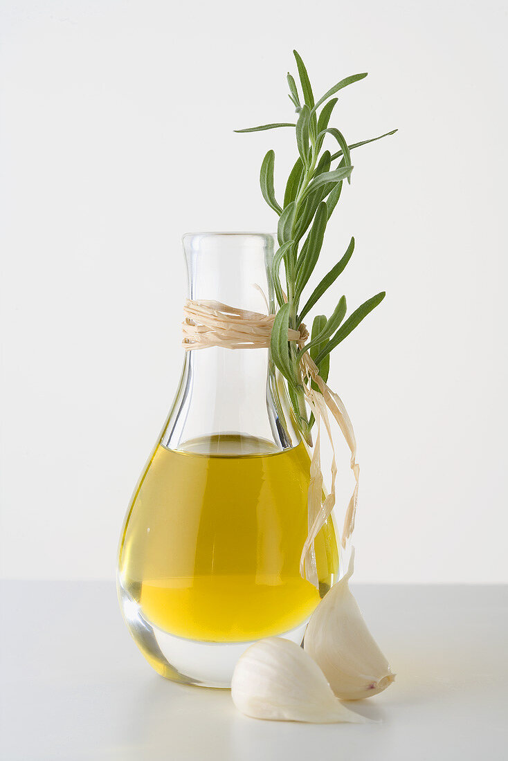 Olivenöl in Karaffe, Knoblauch und frischer Rosmarin