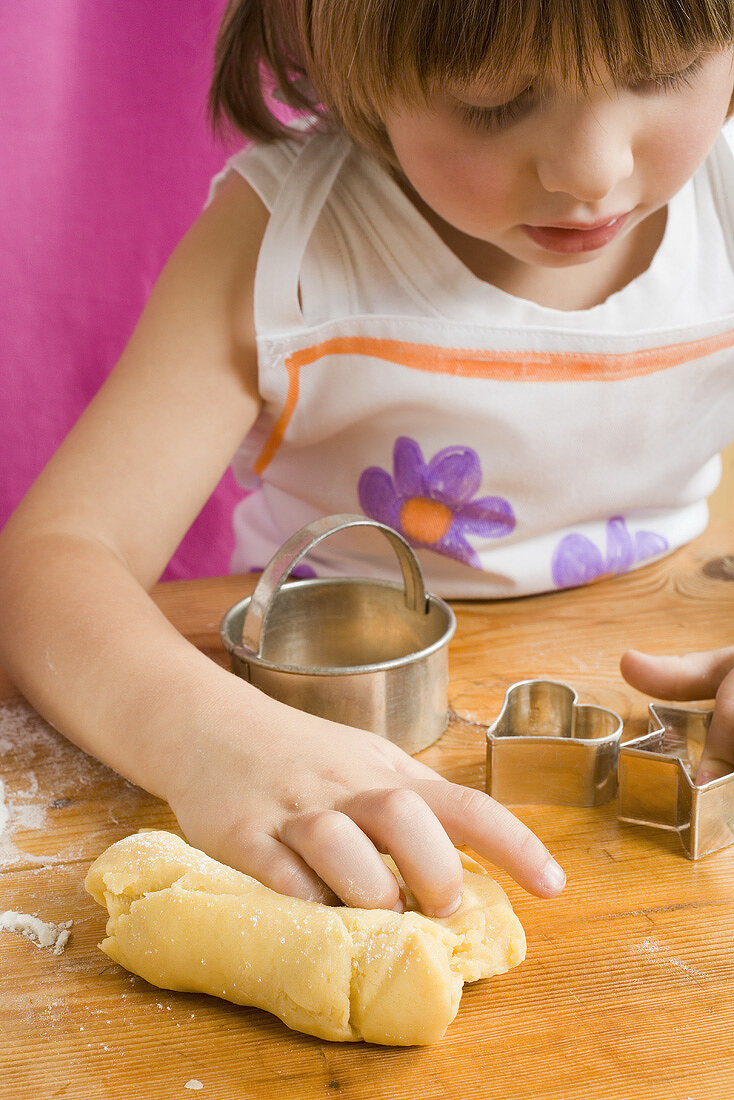 Child with dough and biscuit cutters