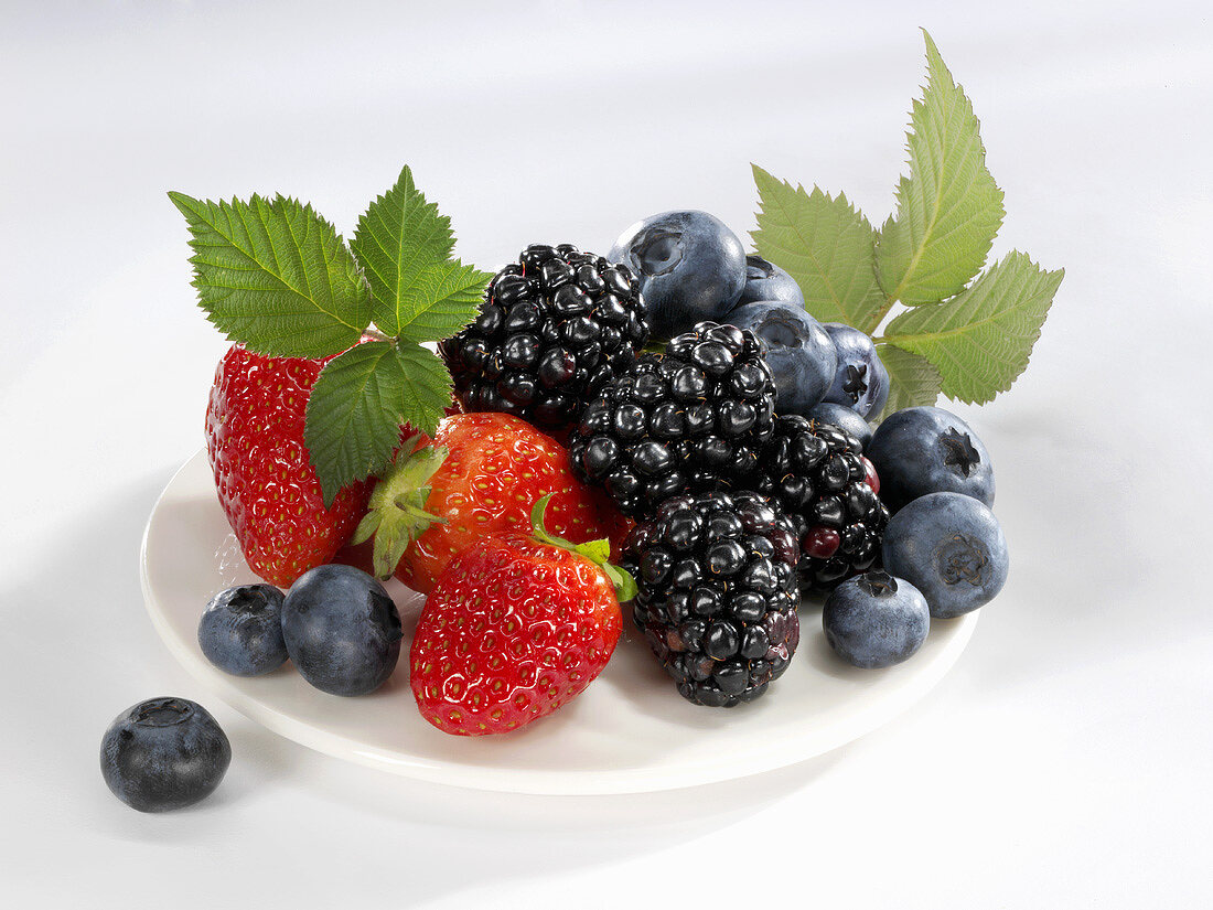 Blueberries, strawberries and blackberries on plate