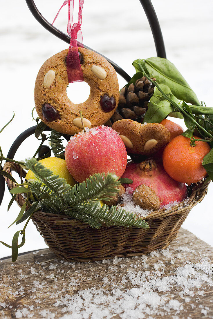 Gingerbread, fruit, nuts and cones in a basket
