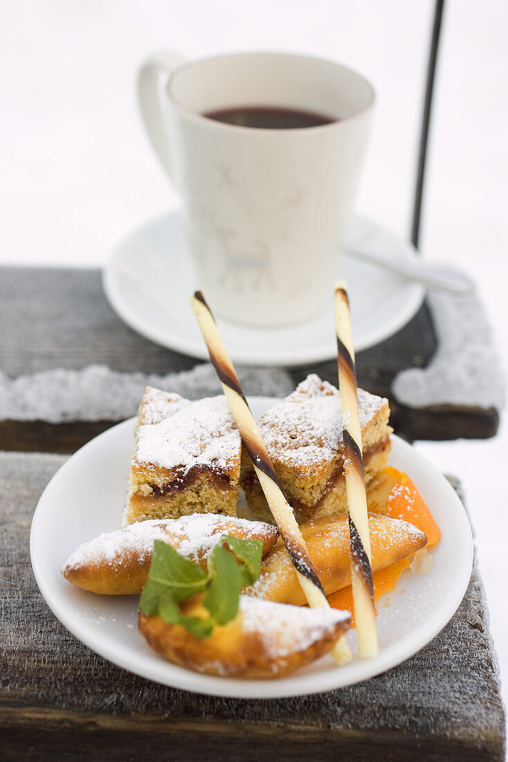 Weihnachtsgebäck auf Teller vor Tasse Punsch