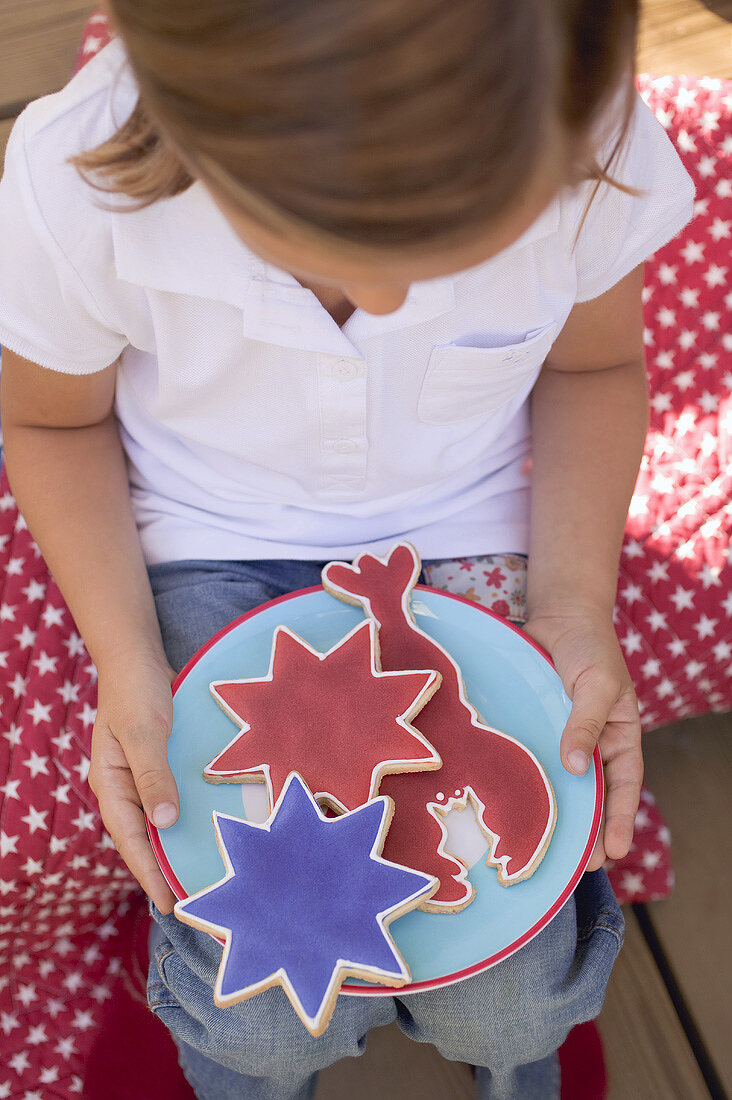 Small girl holding a plate of cookies (4th of July, USA)